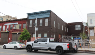a two story building with a blue cornice