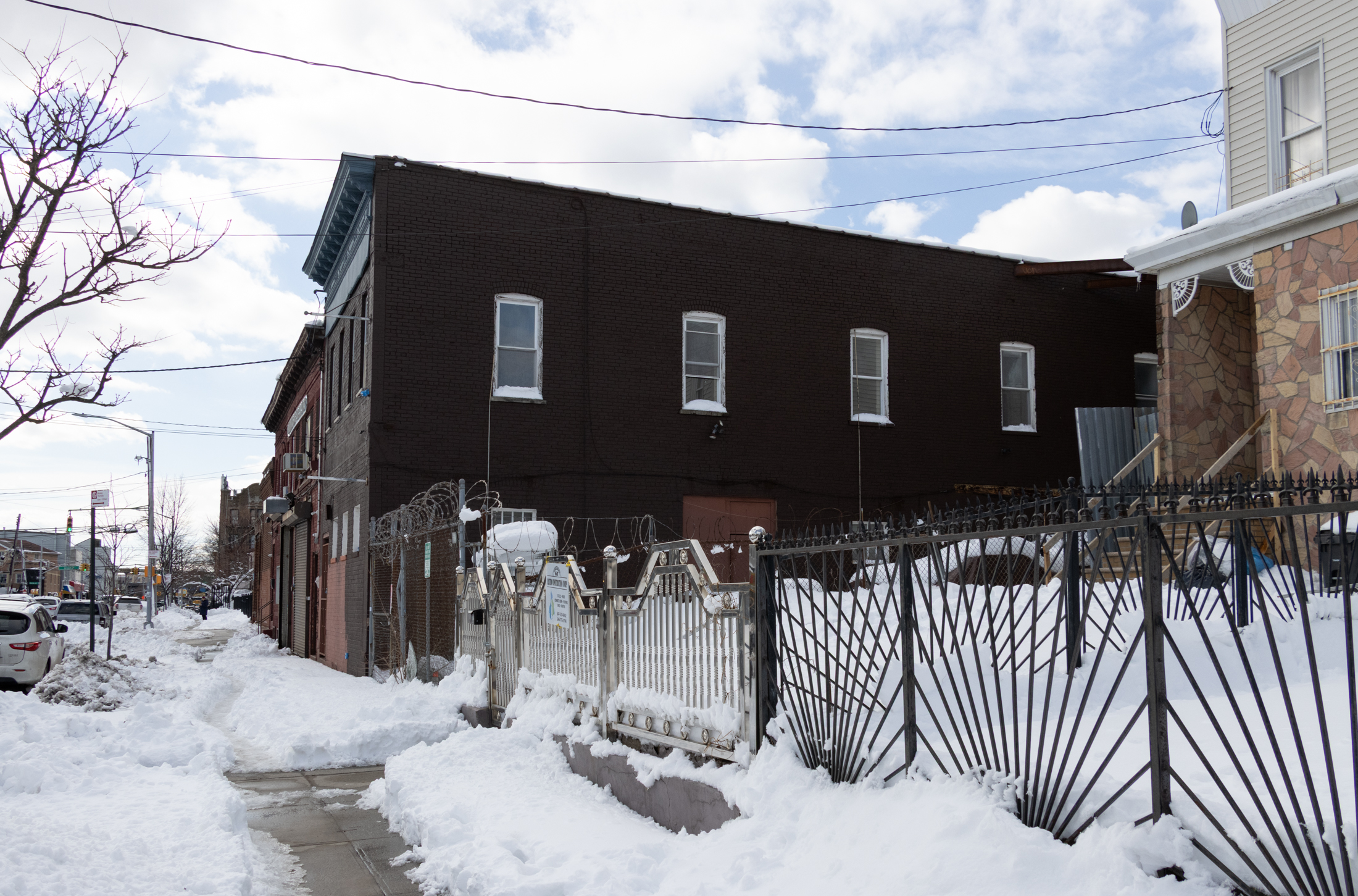 side view of a low scale building next to houses