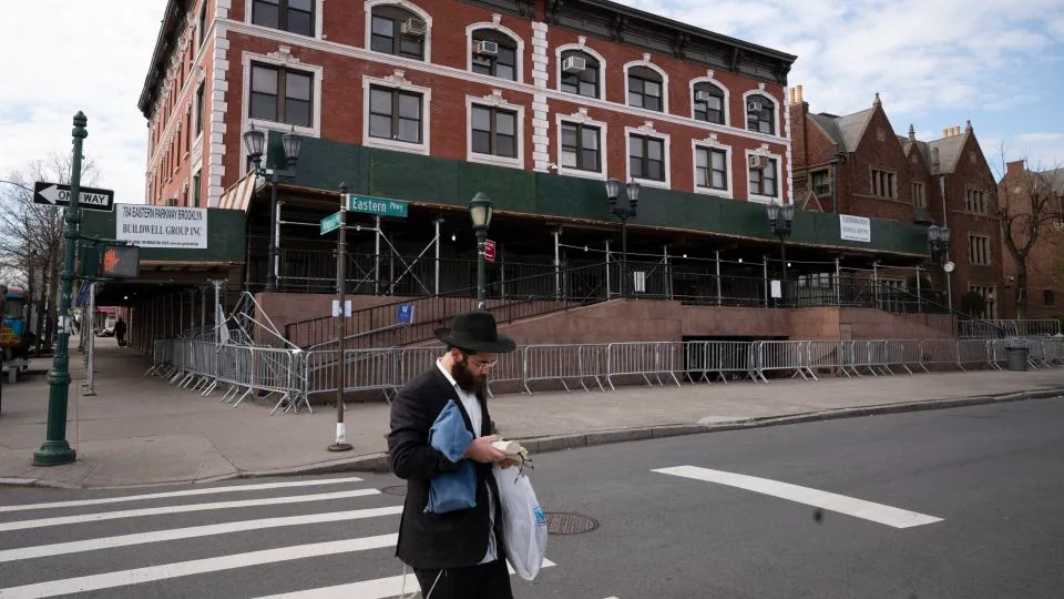 A man passes the Chabad Lubavitch world headquarters in the Crown Heights neighborhood of Brooklyn, on April 7, 2020. - Mark Lennihan/AP