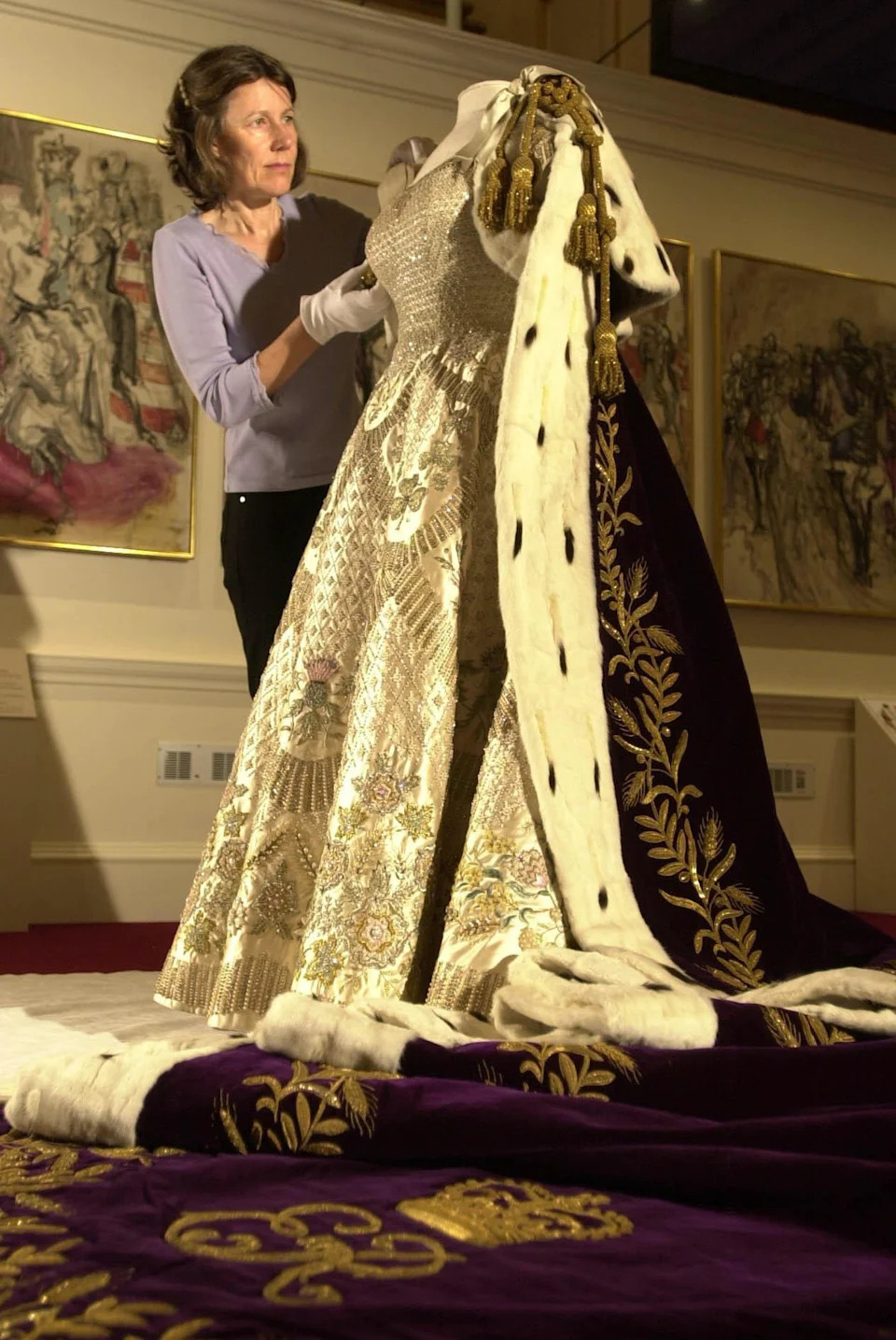 Senior Textile Conservator Jane Wood attends to the Coronation Dress and Robe of Estate in the Ball Supper Room at London's Buckingham Palace. 08/10/03: The dress, which was worn by Britain's Queen Elizabeth II on Coronation Day, will go on display at Windsor Castle. * The dress, which was worn by Britain's Queen Elizabeth II on Coronation Day, will be on show as part of this year's summer opening of the State Rooms.