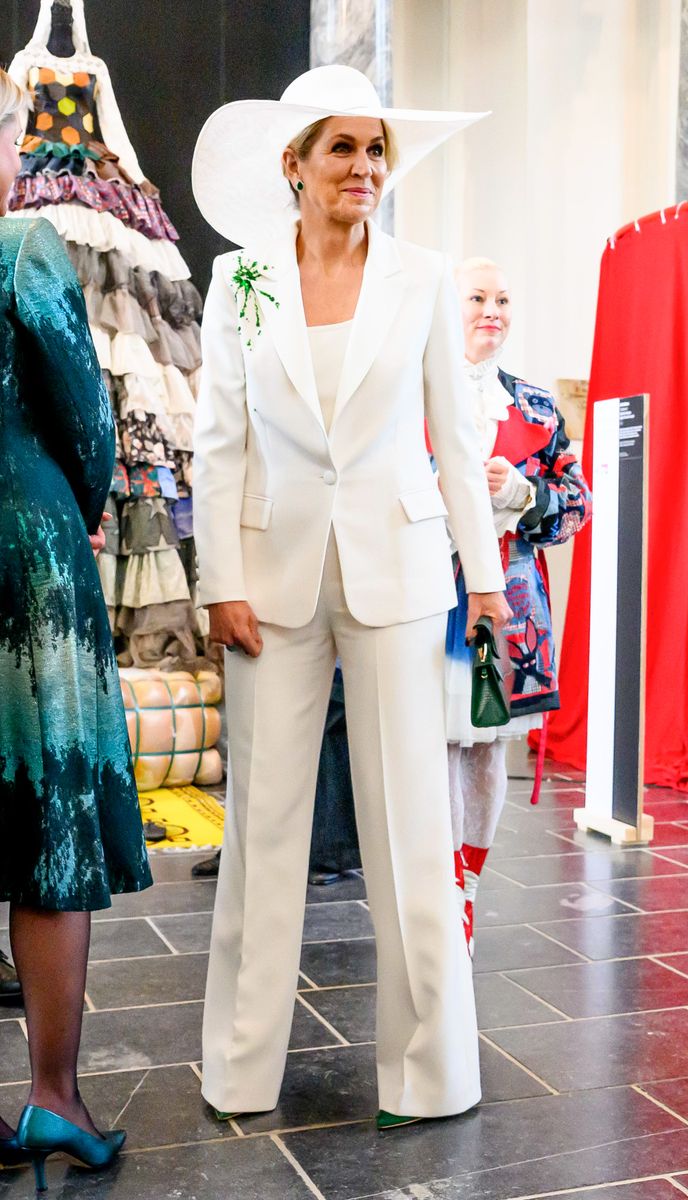 The standout detail of the look was the unexpected splash of vibrant green paint across the right shoulder of the blazer.