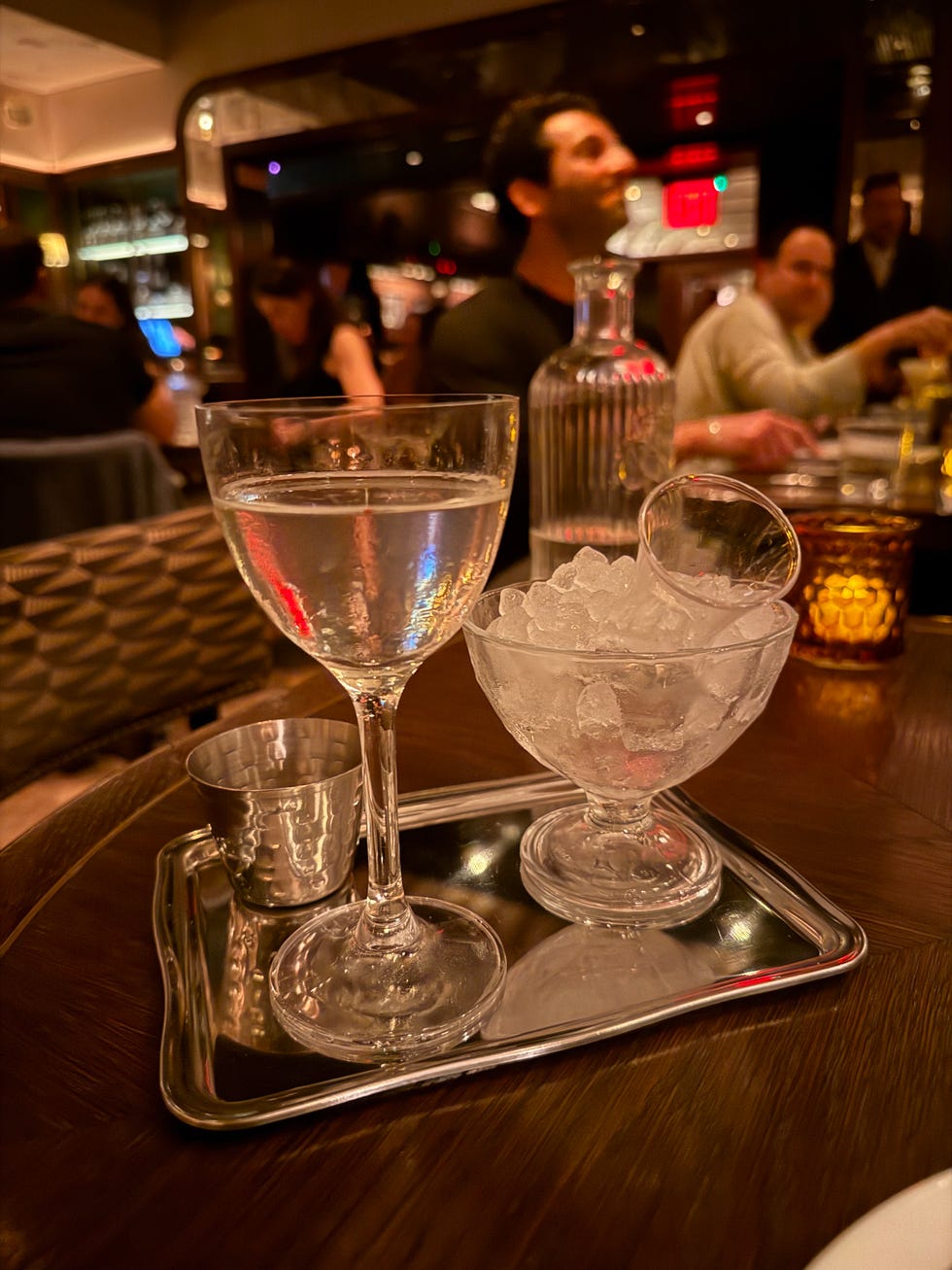 Serving tray with a cocktail, an ice bowl, and a silver cup. Serving tray with a cocktail, an ice bowl, and a silver cup.