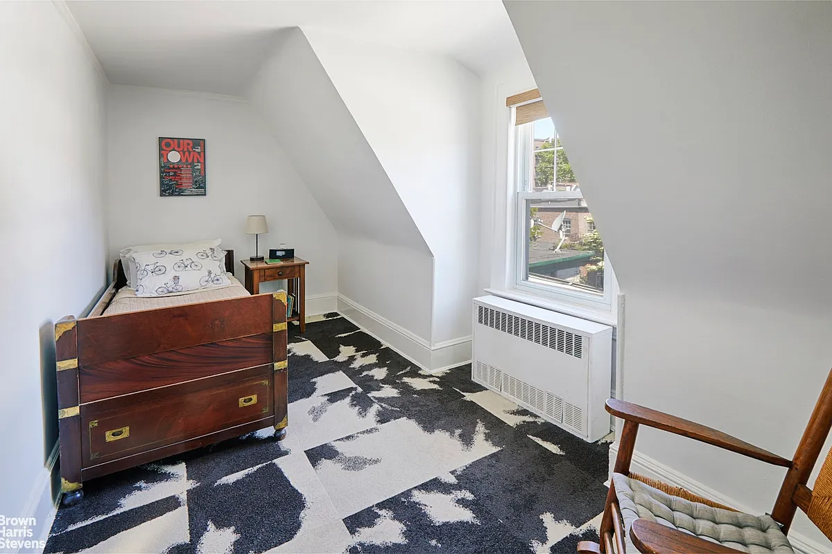 narrow bedroom with cowhide patterned carpet tiles