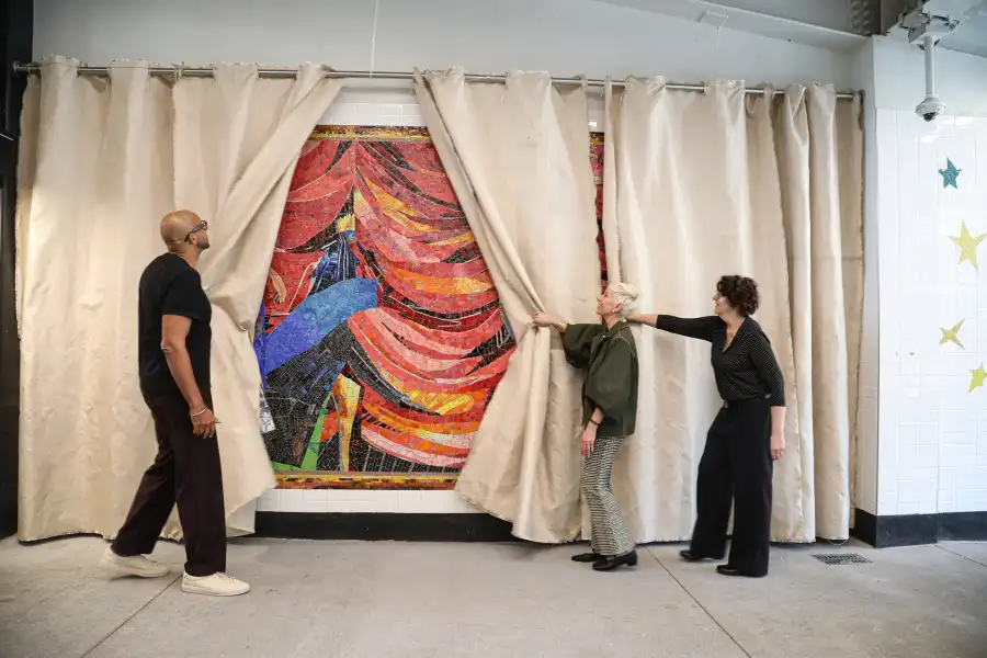 people pulling back a curtain