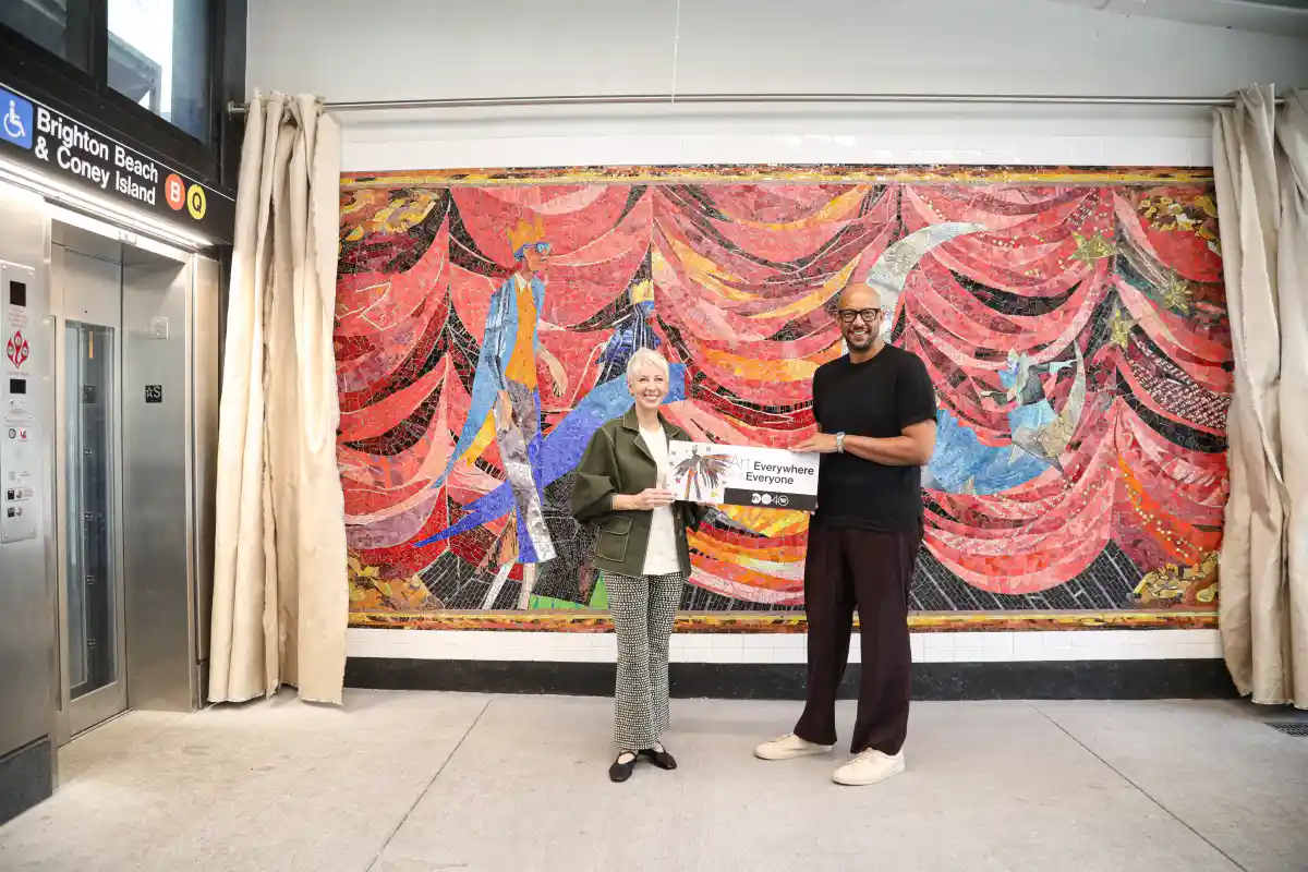 people in front of a mosaic mural