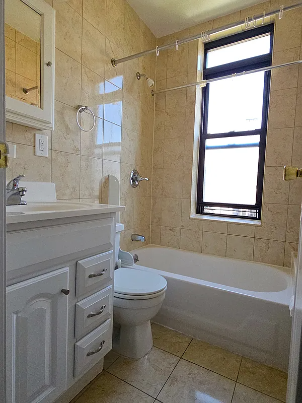 bathroom with white fixtures and beige wall and floor tiles