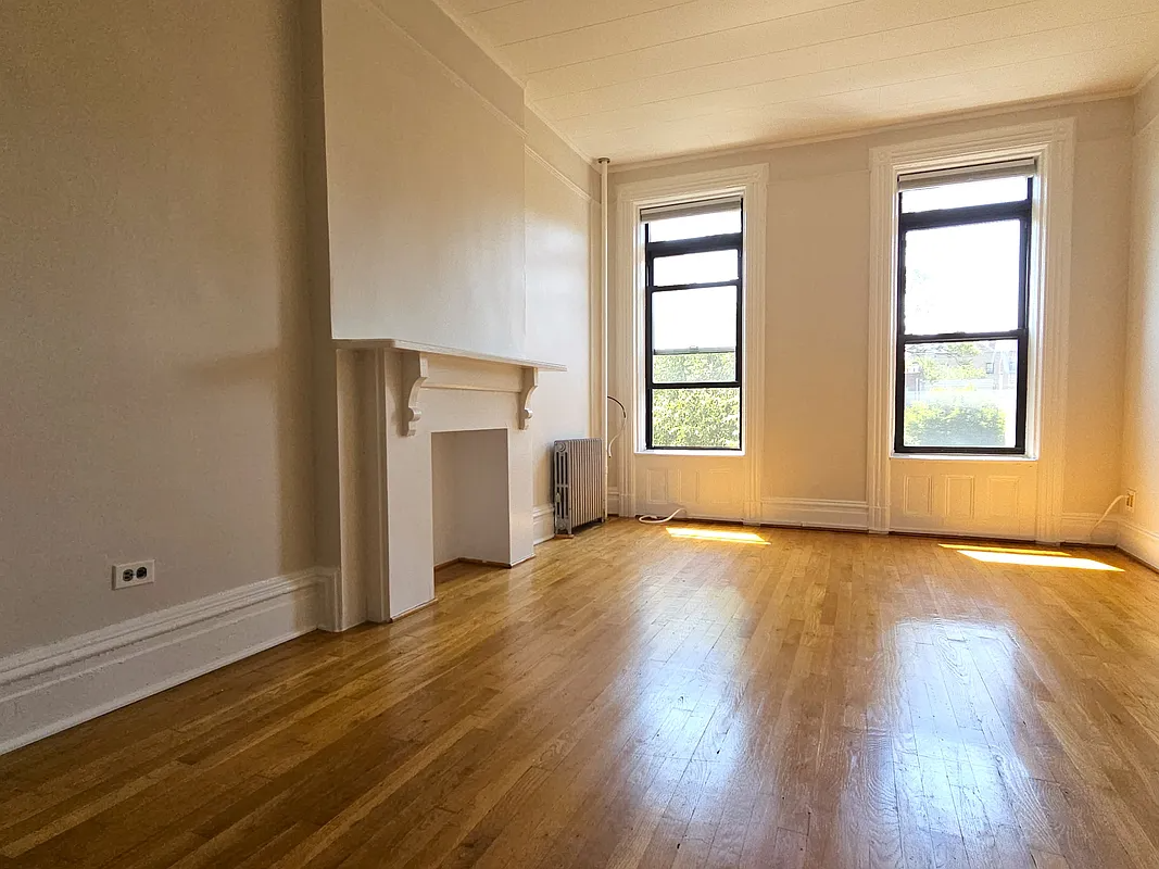 room with wood floor, picture rail, mantel