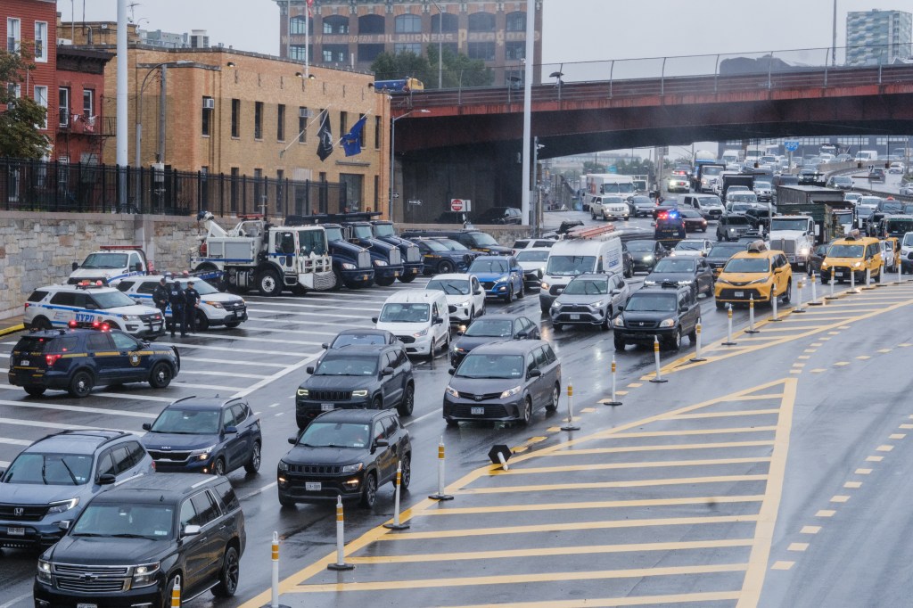 Heavy traffic with law enforcement present at the entrance of the Queens Midtown Tunnel.