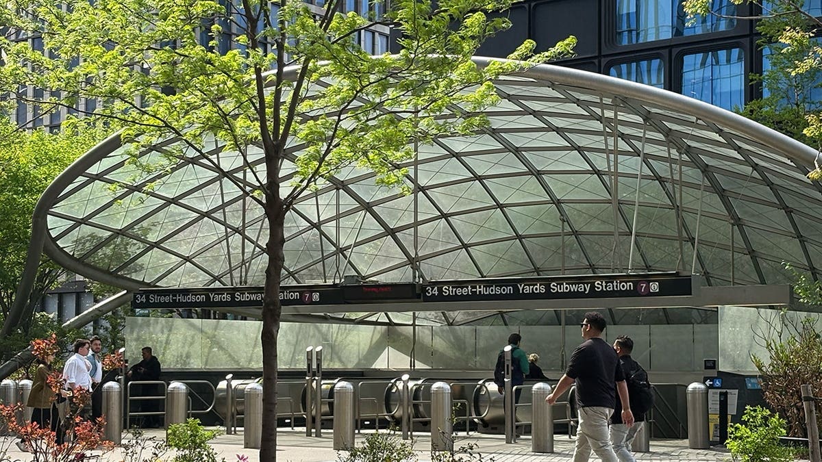 34 Street–Hudson Yards subway station entrance with glass canopy and commuters in Manhattan NYC.