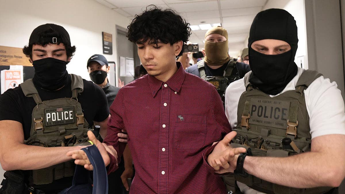Federal agents detaining an individual outside immigration court at the Jacob K. Javits Federal Building in New York City