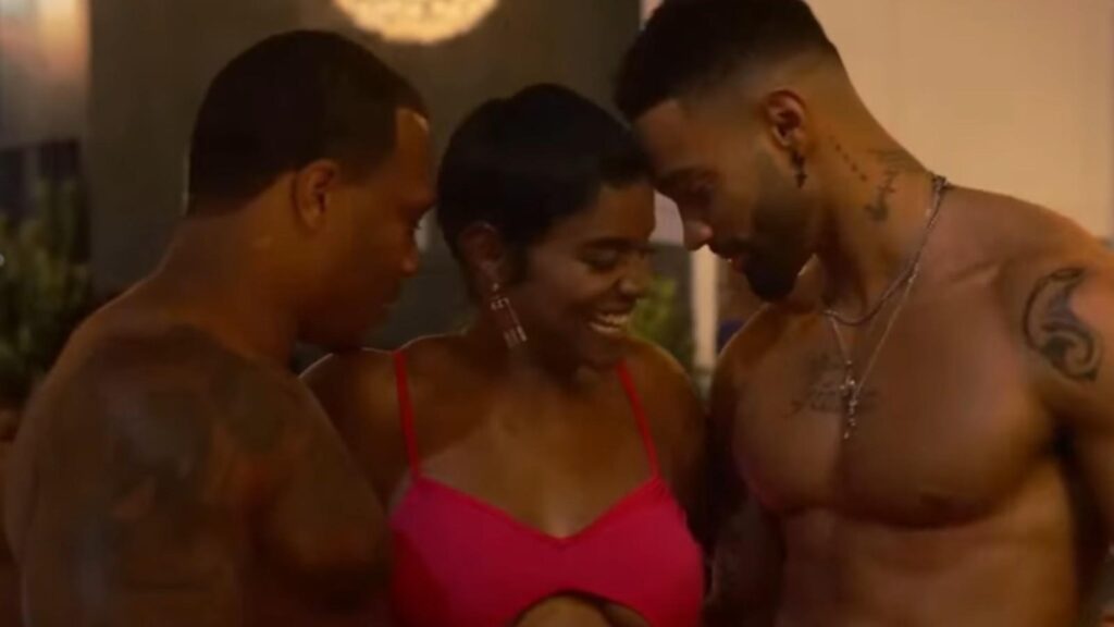 Eva Marcille as Madam with male dancers in tense scene, from All The Queens Men Season 4