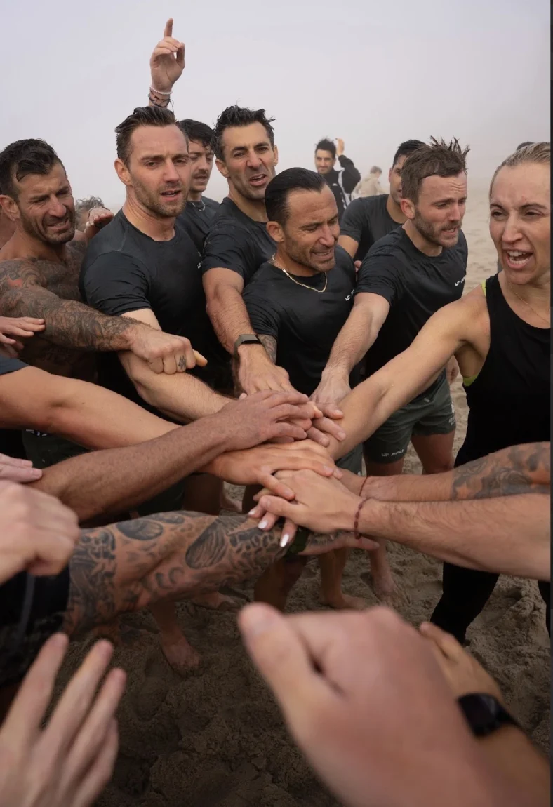 people come together in a huddle and grasp hands