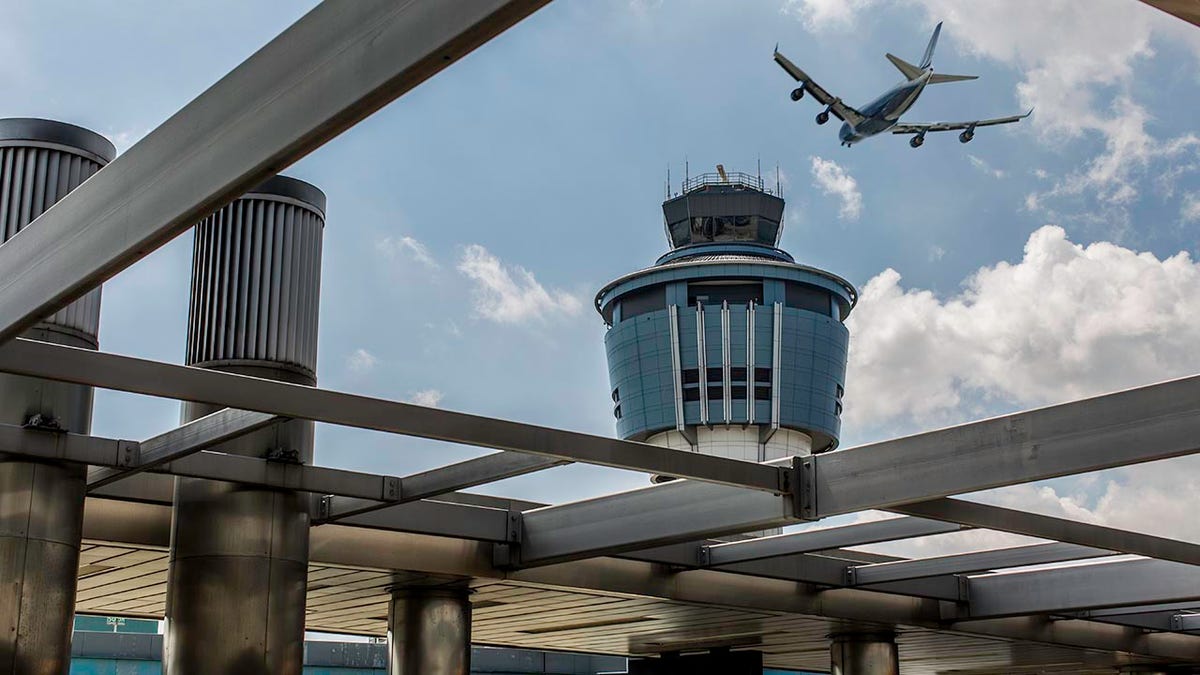 A plane flying over LaGuardia Airport tower in New York