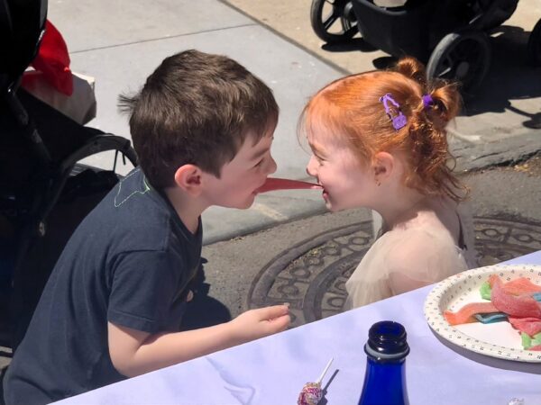 From left: Ryder Mathews and Logan Renert play the “spaghetti game” at the Longest Table on Saturday. Photo: Mary Frost/Brooklyn Eagle