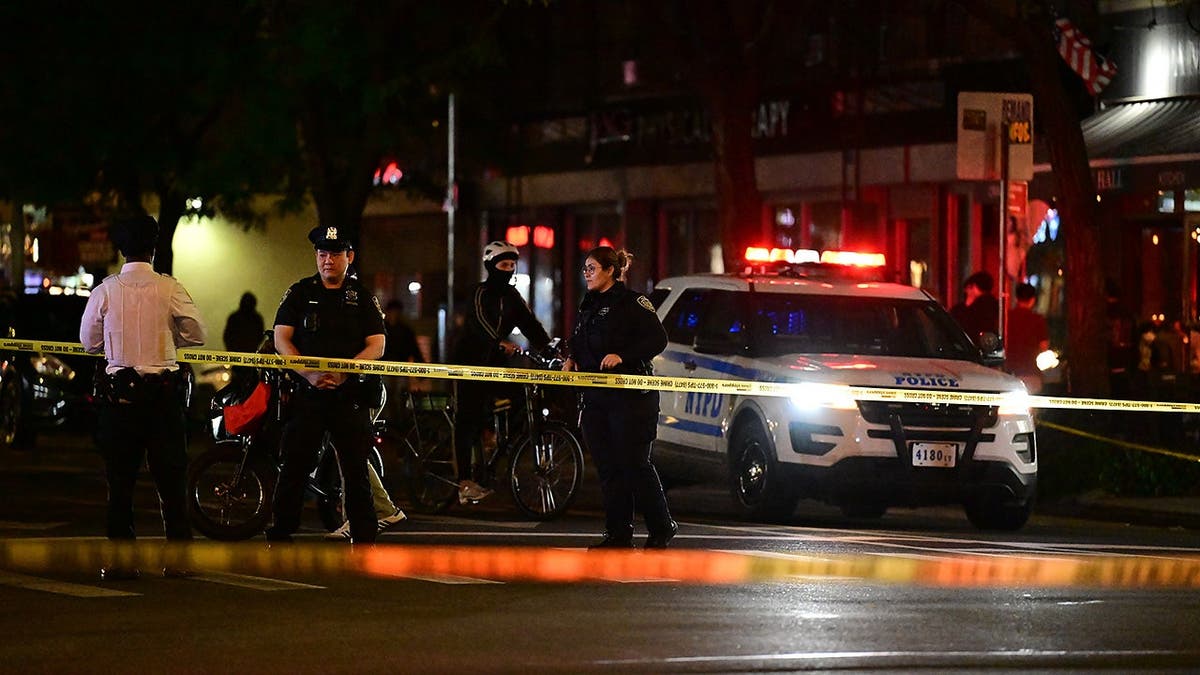 Two people lying on a sidewalk with emergency responders attending to them