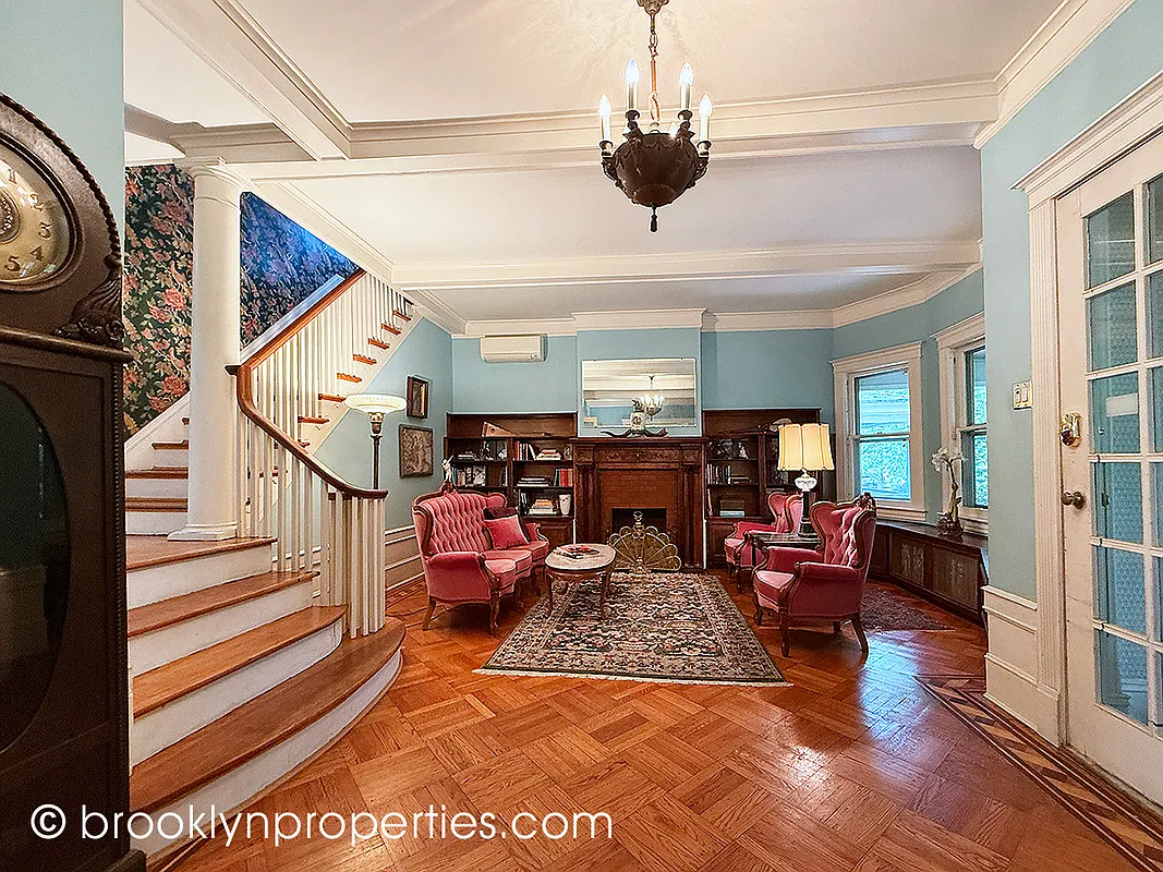 entry hall with a fireplace, stair, and wood floor