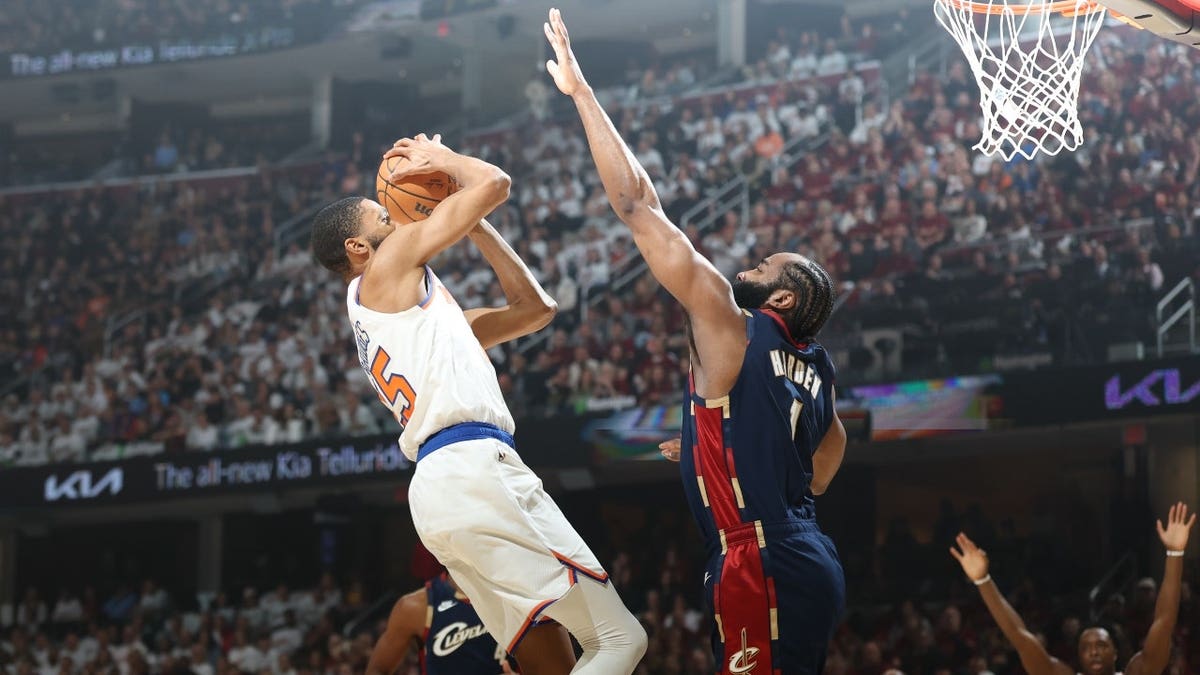 New York Knicks forward Mikal Bridges shooting while defended by Cleveland Cavaliers guard James Harden at Rocket Arena
