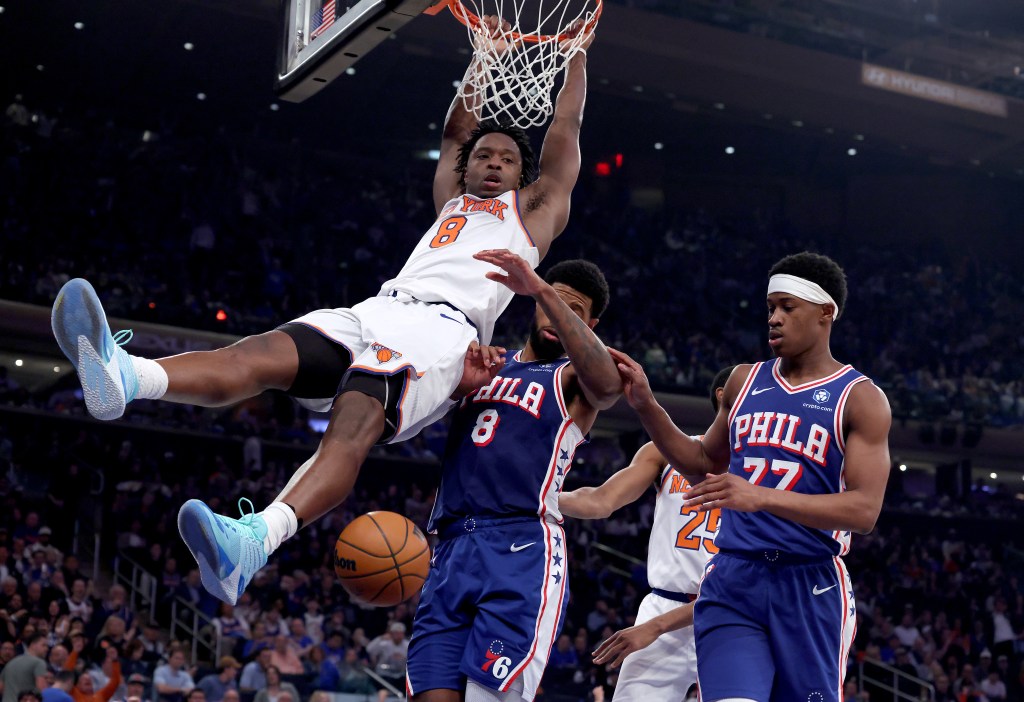 New York Knicks forward OG Anunoby #8 slams the ball over Philadelphia 76ers forward Paul George #8 and Philadelphia 76ers guard Vj Edgecombe #77 during the third quarter. 
