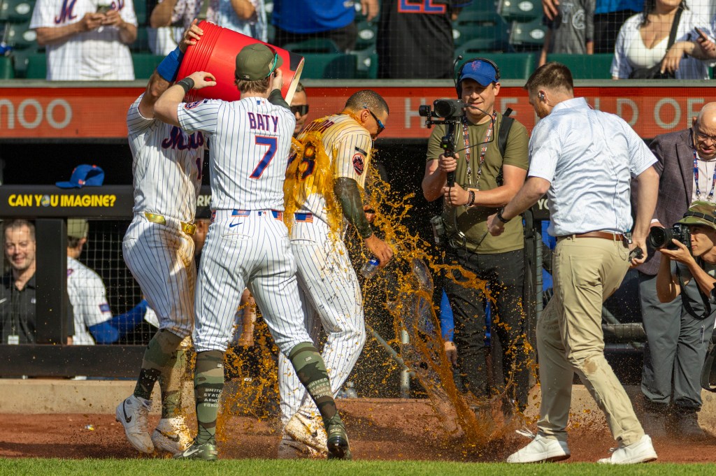 New York Mets players dump a cooler of Bodyarmor on center fielder Tyrone Taylor during a celebration.
