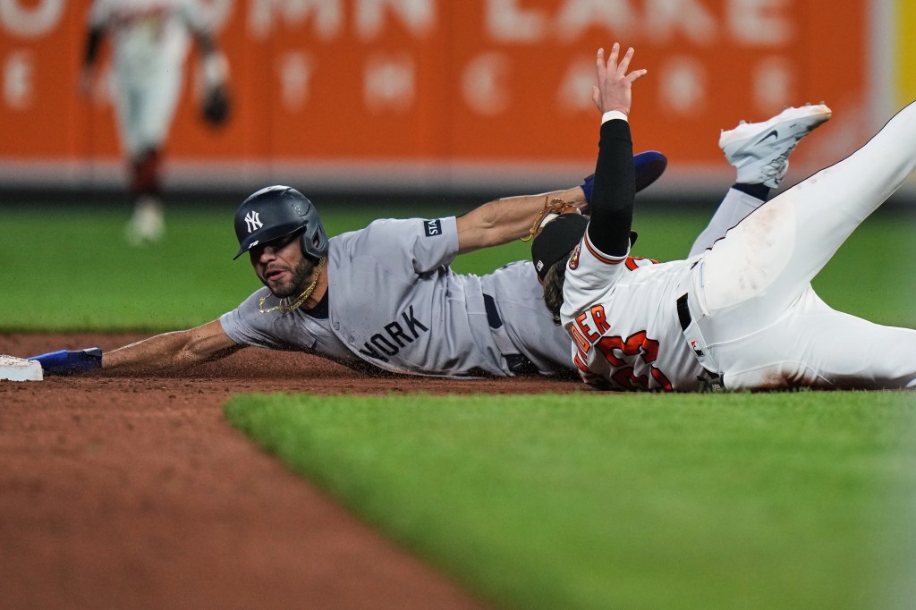 New York Yankees' José Caballero slides into second base as Baltimore Orioles second baseman Blaze Alexander attempts to catch him.