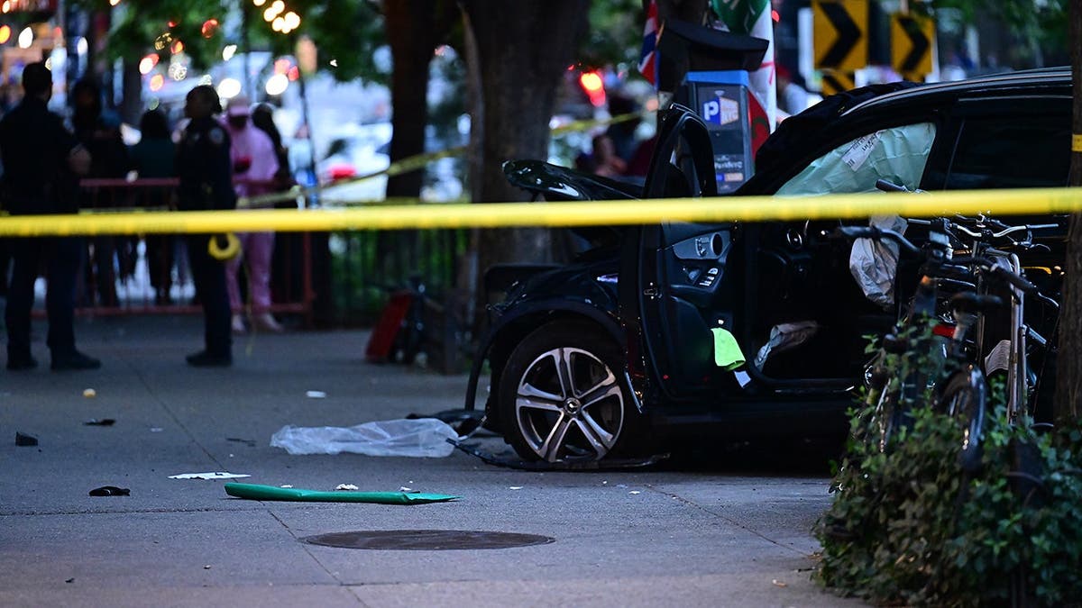 Two people lying on a sidewalk with emergency responders attending to injured pedestrians