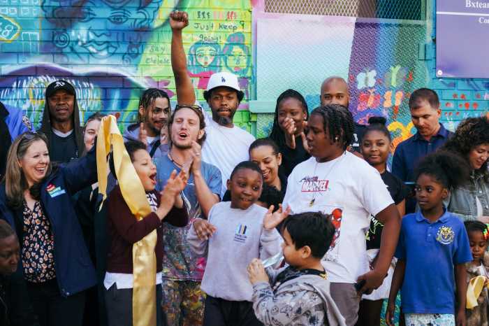 Community members celebrate the unveiling of the "Unity in Our Community" mural.