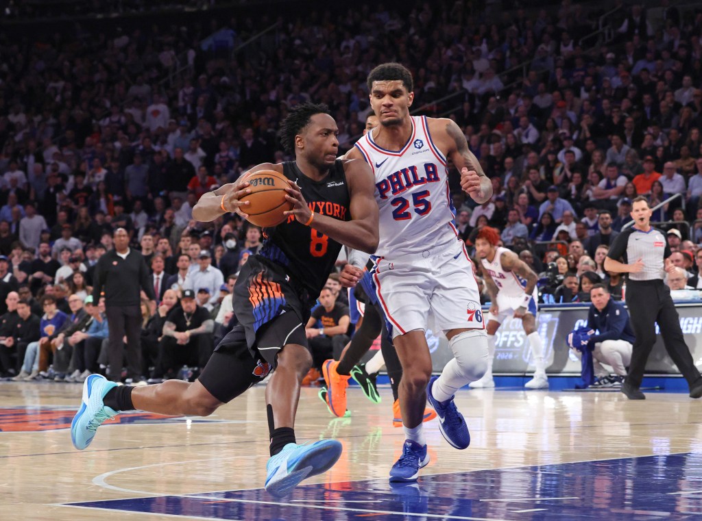 New York Knicks player Og Anunoby driving to the basket with a Philadelphia 76ers player guarding him during an NBA playoffs game.