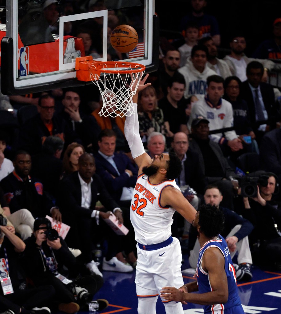New York Knicks center Karl-Anthony Towns shoots a basket over Philadelphia 76ers center Joel Embiid.