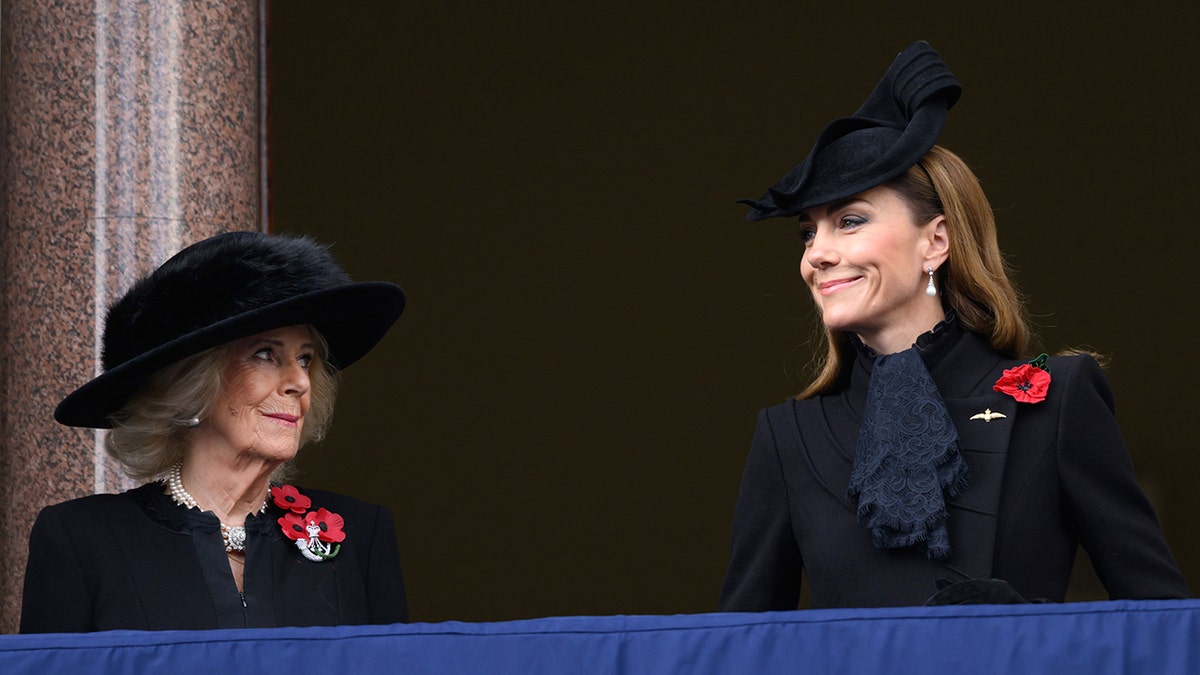 Queen Camilla and Catherine Princess of Wales smiling on Buckingham Palace balcony