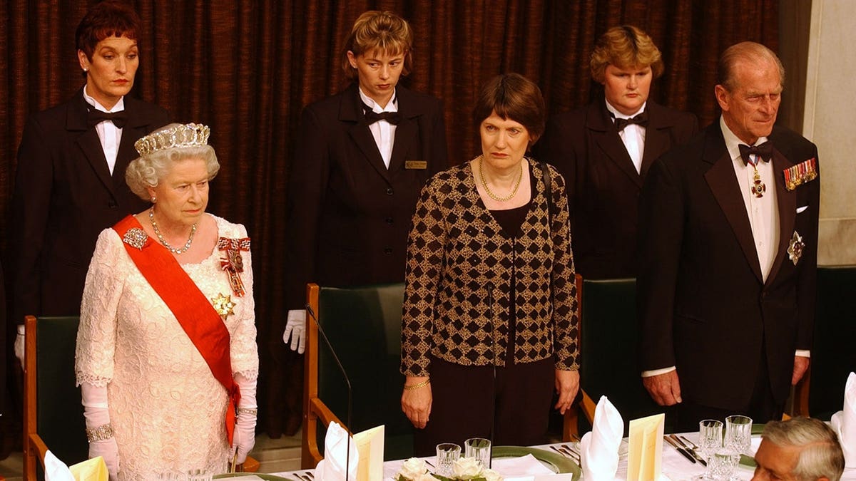 Queen Elizabeth II standing with New Zealand Prime Minister Helen Clark and the Duke of Edinburgh at a state banquet