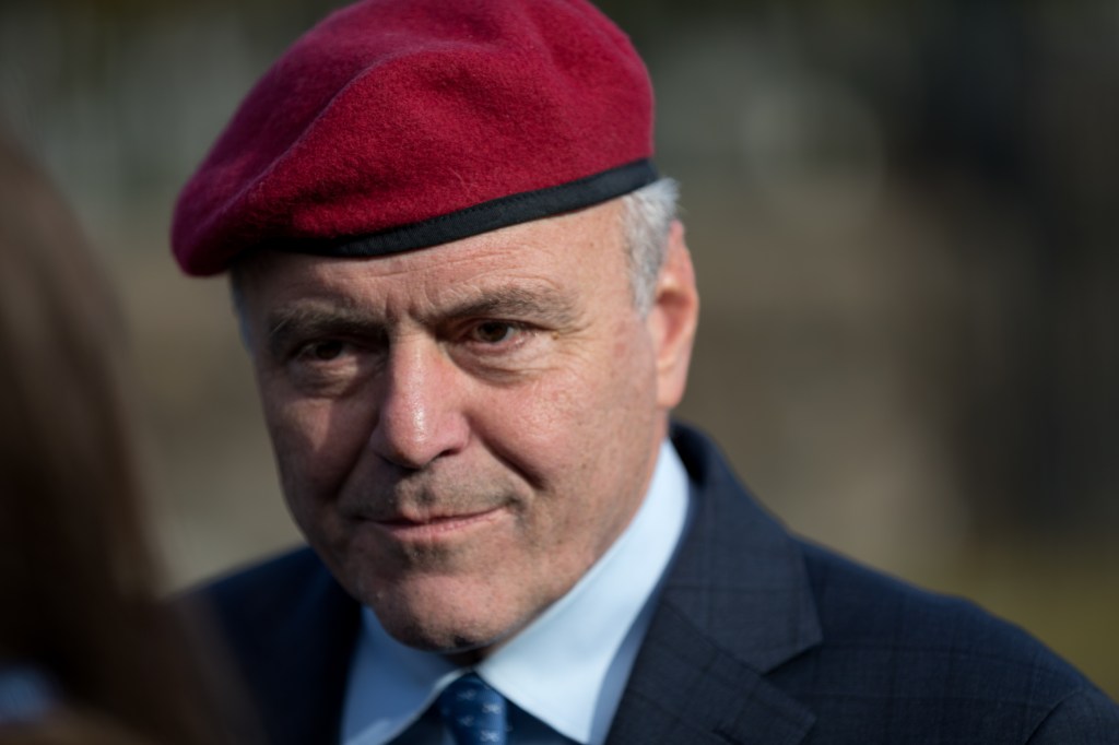Close-up of Curtis Sliwa wearing a red beret, blue shirt, and blue tie.