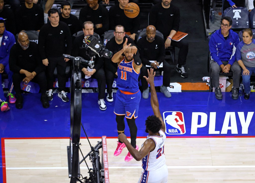 New York Knicks guard Jalen Brunson (11) shoots a three-pointer over Philadelphia 76ers center Joel Embiid (21).