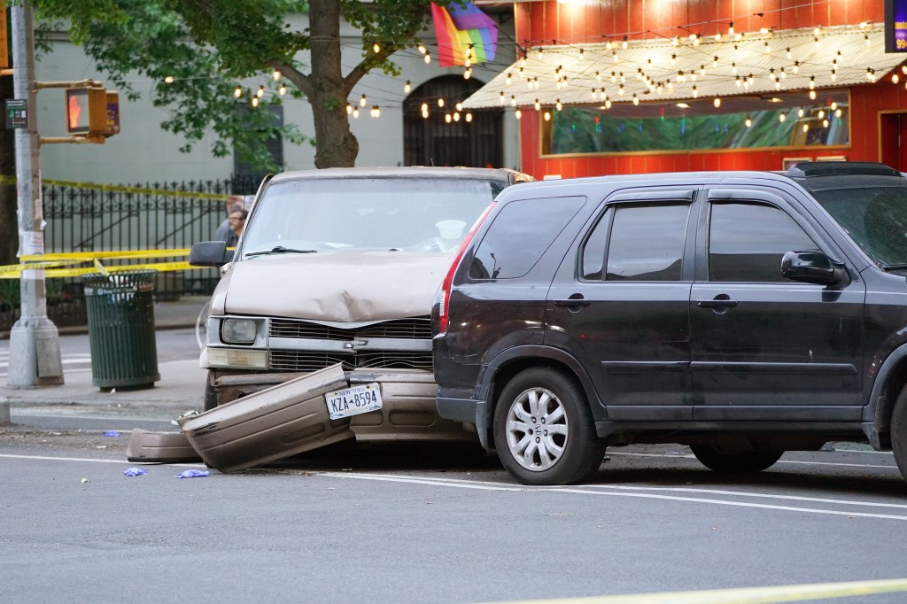 Two damaged cars, a light brown van and a dark SUV, with a New York license plate on the van and crime scene tape in the background.