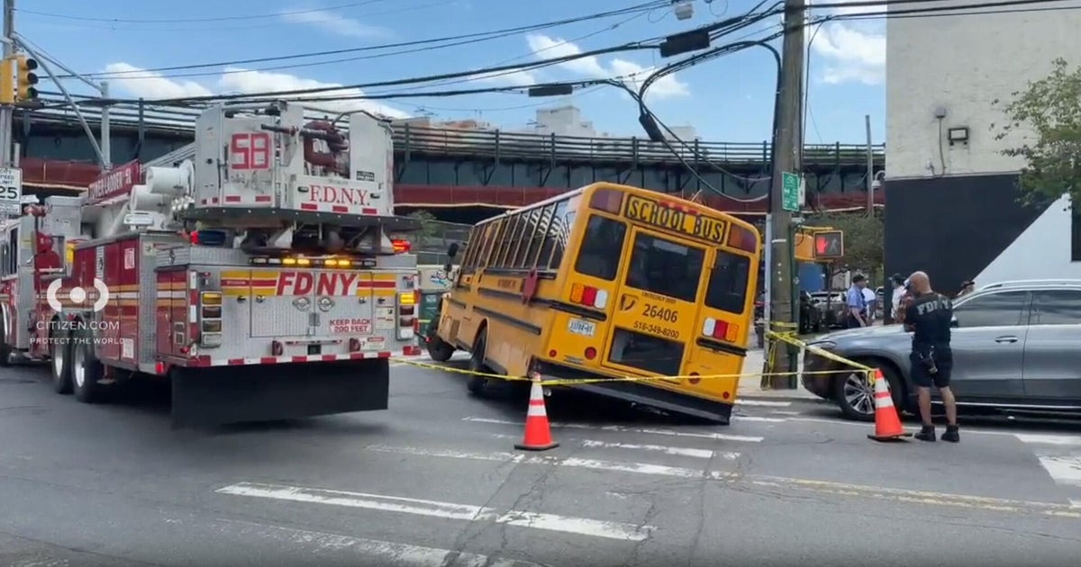 School bus in the Bronx partially trapped in a hole