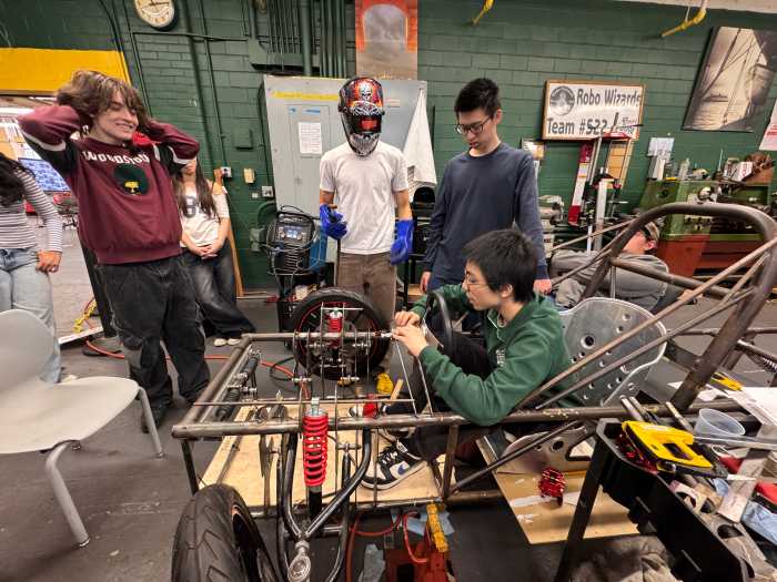 students in a garage working on a solar car