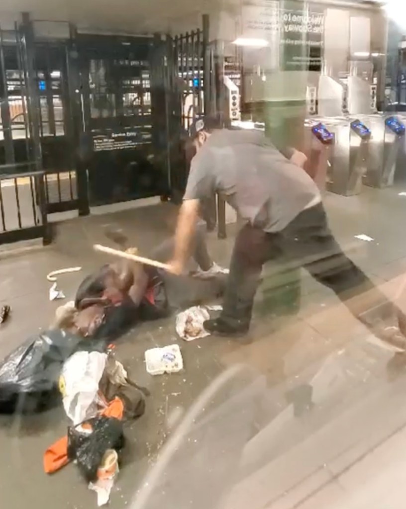 Man assaults a prone person with a stick in a subway station.