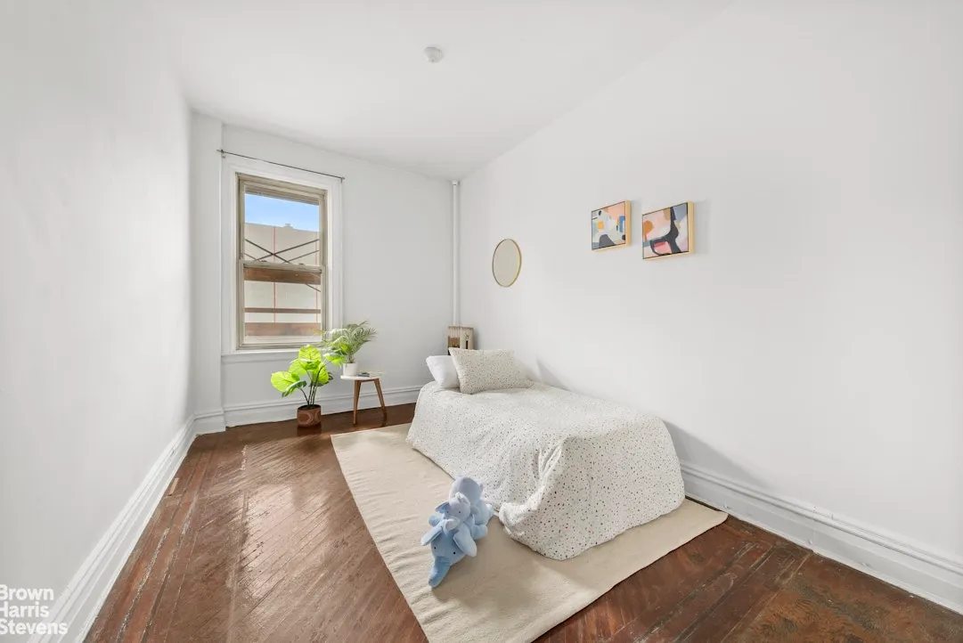 bedroom with white walls, wood floor