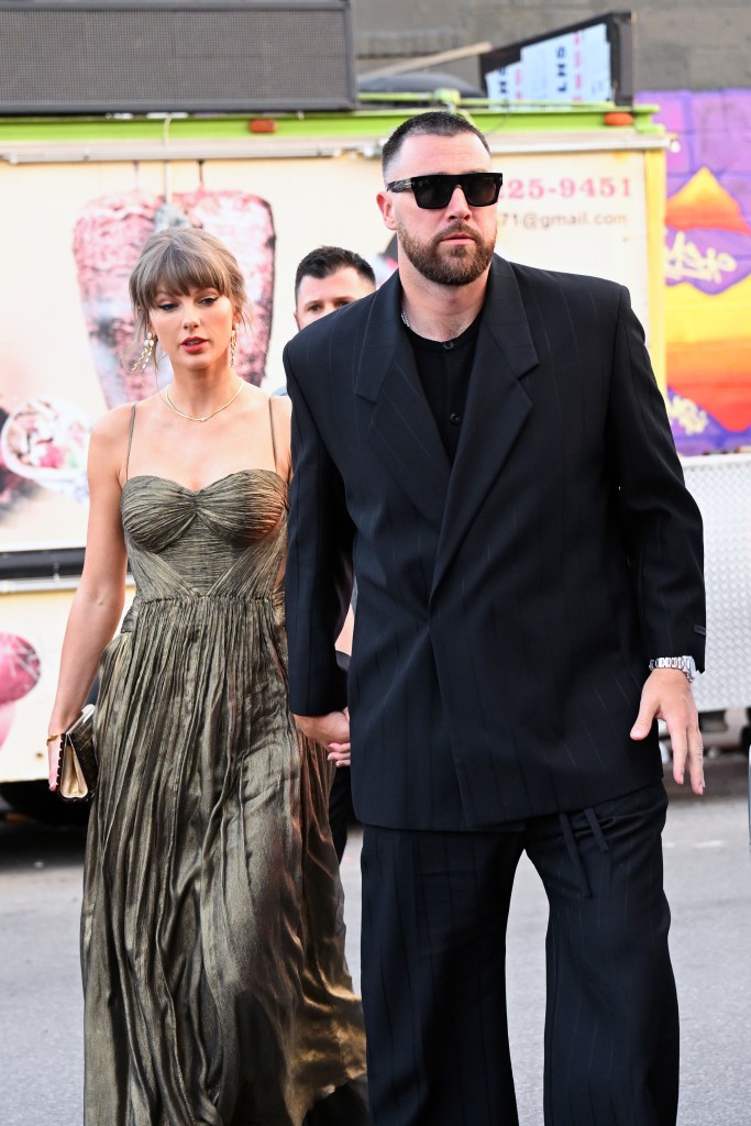 Taylor Swift in a gold dress and Travis Kelce in a dark suit walking together.
