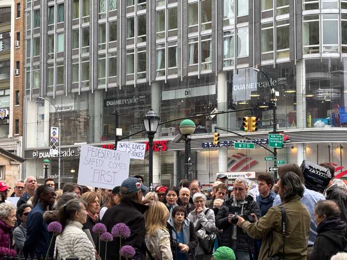 group of people outside holding protest signs on the Upper West Side