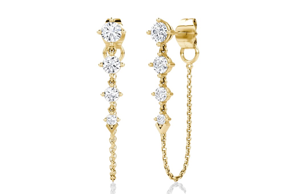 A pair of gold earrings with brilliant cut diamonds, one with a dangling chain and the other with a shorter chain.