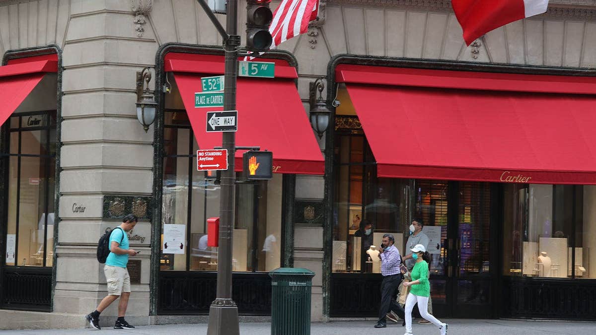 People walk near the Cartier store on Fifth Avenue as New York City