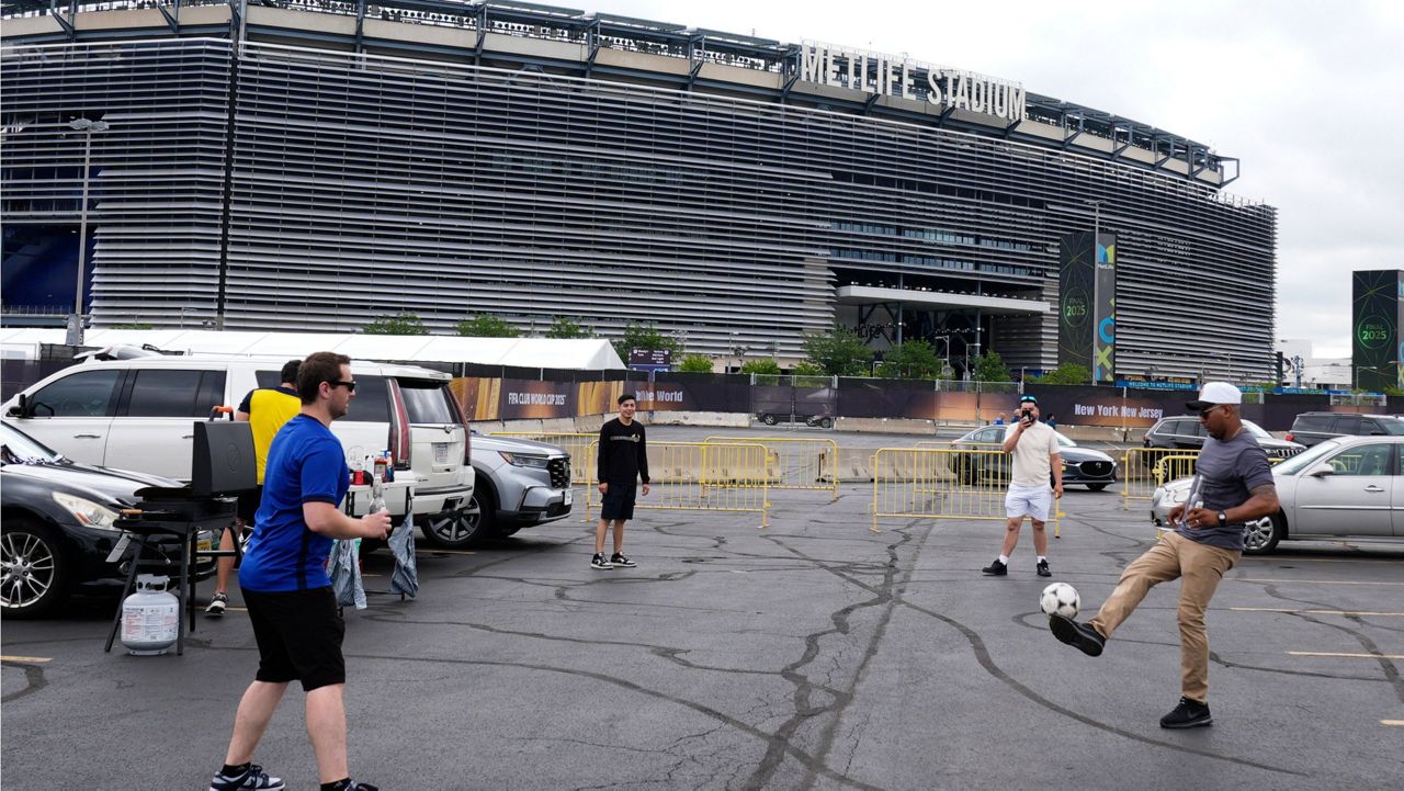Fans play with a soccer ball outside the Metlife Stadium in East Rutherford, N.J., Sunday, July 13, 2025. (AP Photo/Pamela Smith, File)