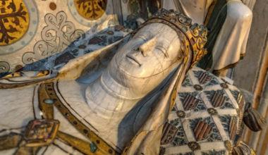 carved and painted sarcophagus that looks like a woman sleeping peacefully