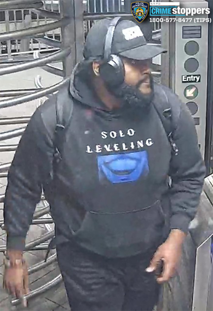 Surveillance image of a male suspect wearing a black hoodie with "Solo Leveling" text and a blue graphic, black pants, a black baseball cap, and headphones, at a subway turnstile.