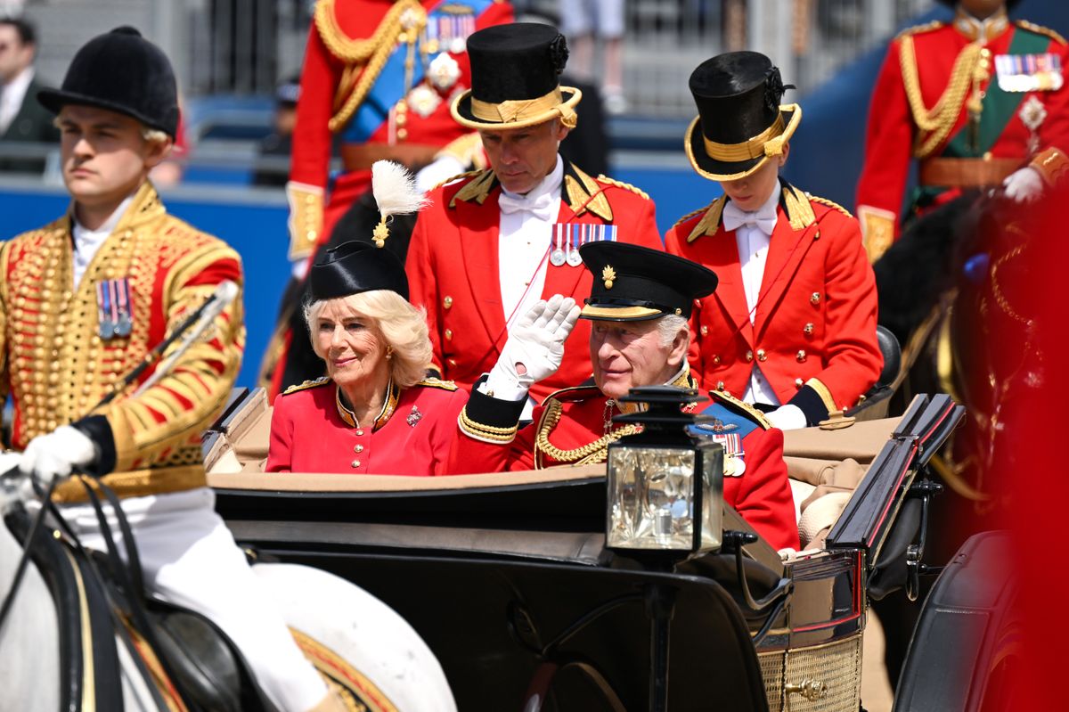 King Charles and Queen Camilla ride in an open carriage as crowds gather for Trooping the Colour.
