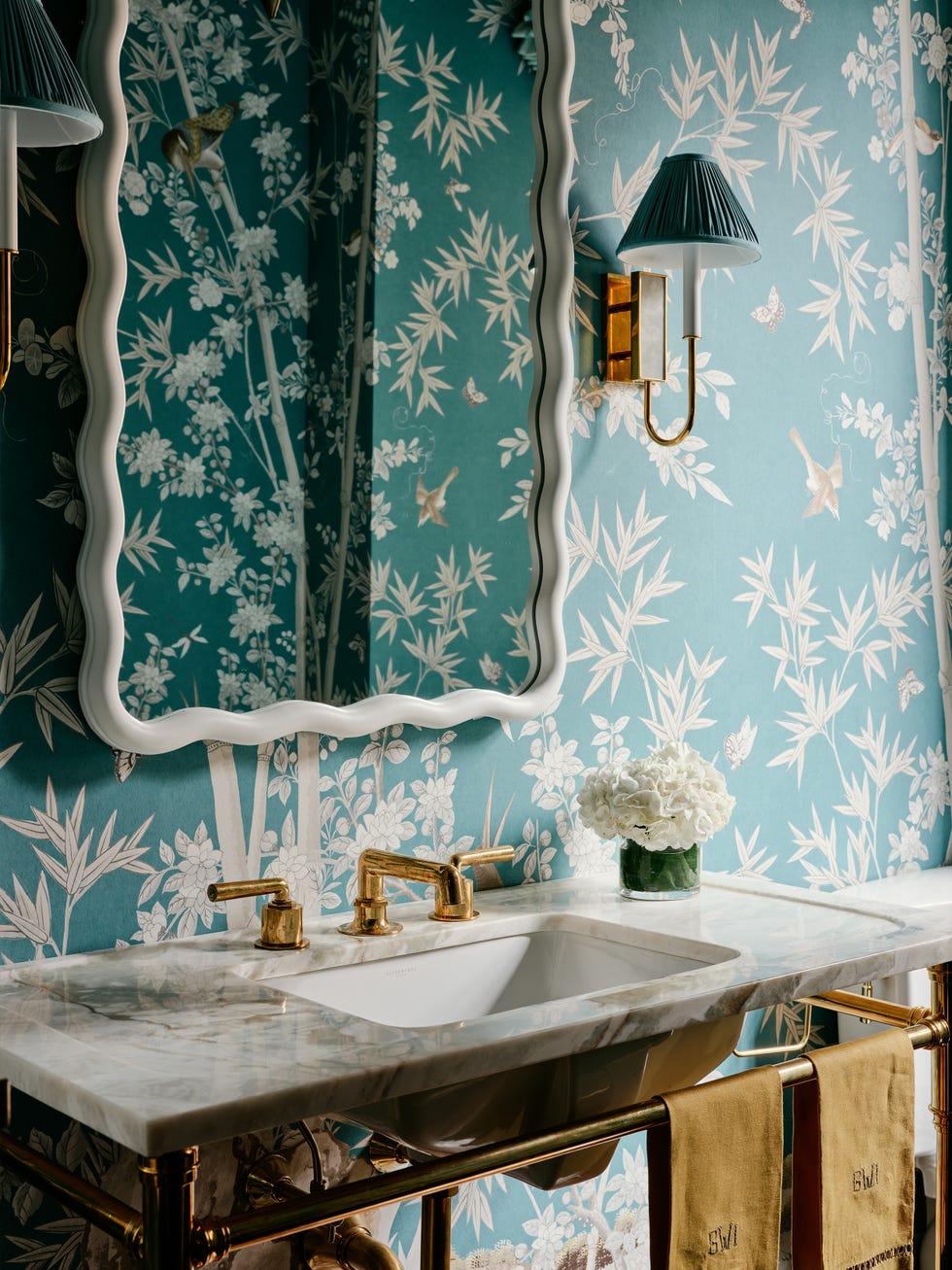 Ornate bathroom with floral wallpaper, marble sink, and gold fixtures.