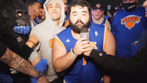 Excited group of fans cheering at a sports event in Knicks jerseys. Excited group of fans cheering at a sports event in Knicks jerseys.