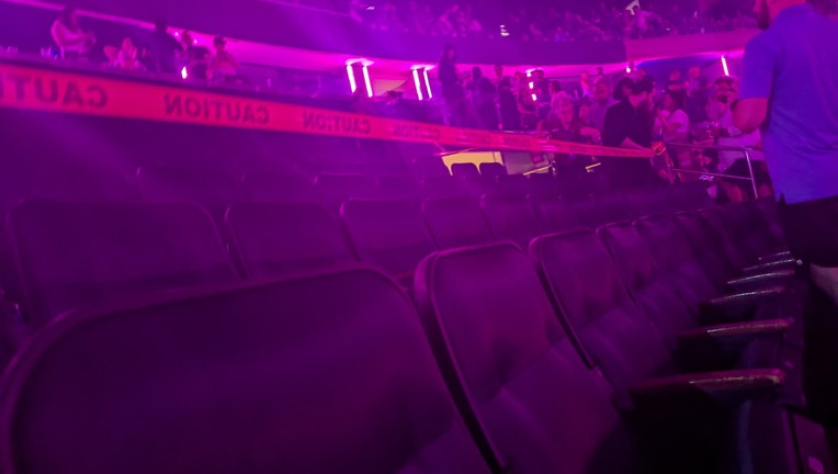Empty theater seats with "CAUTION" tape across the back rows.