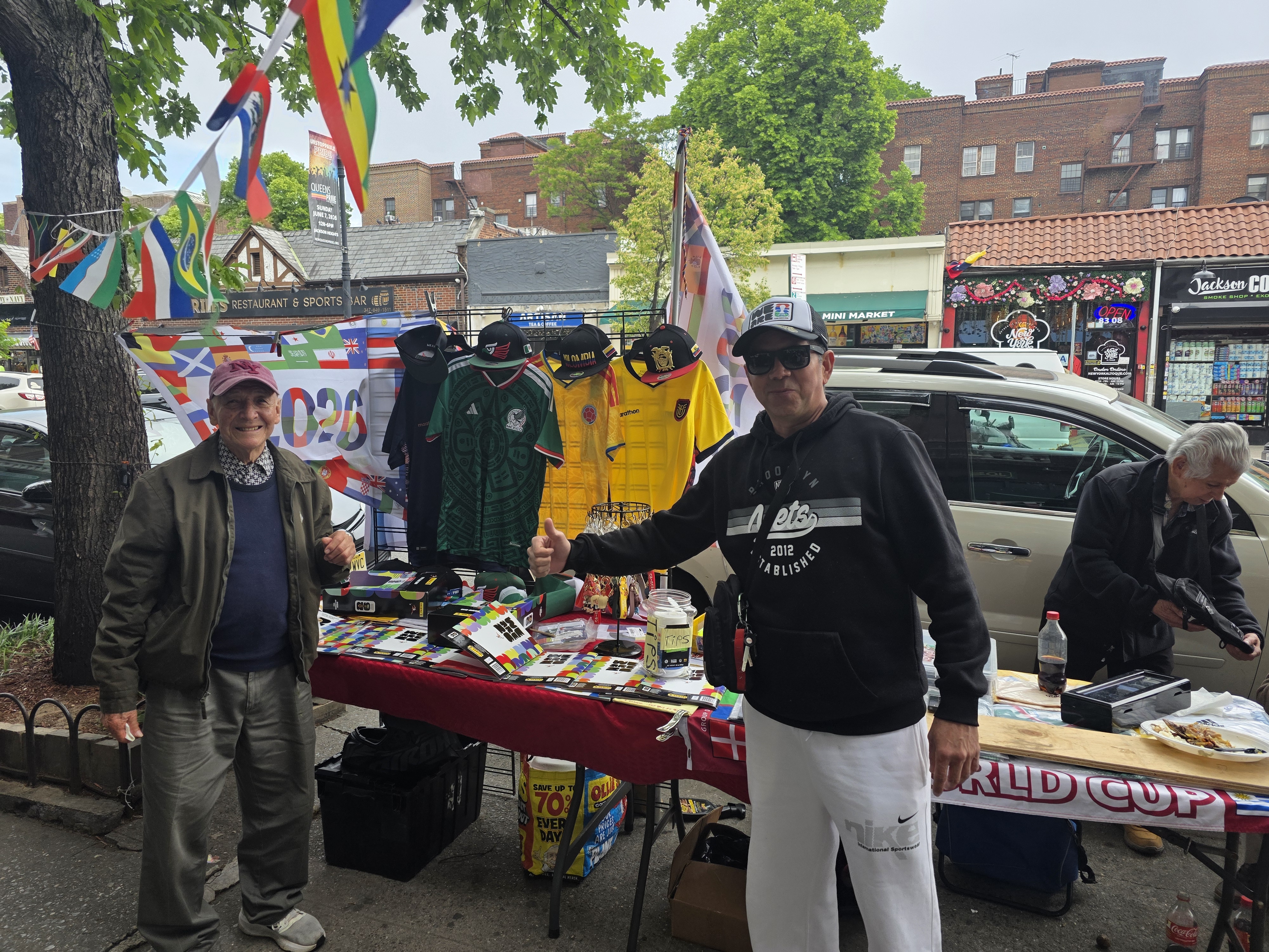 Gustavo Estrada (left) at his stall in Jackson Heights.