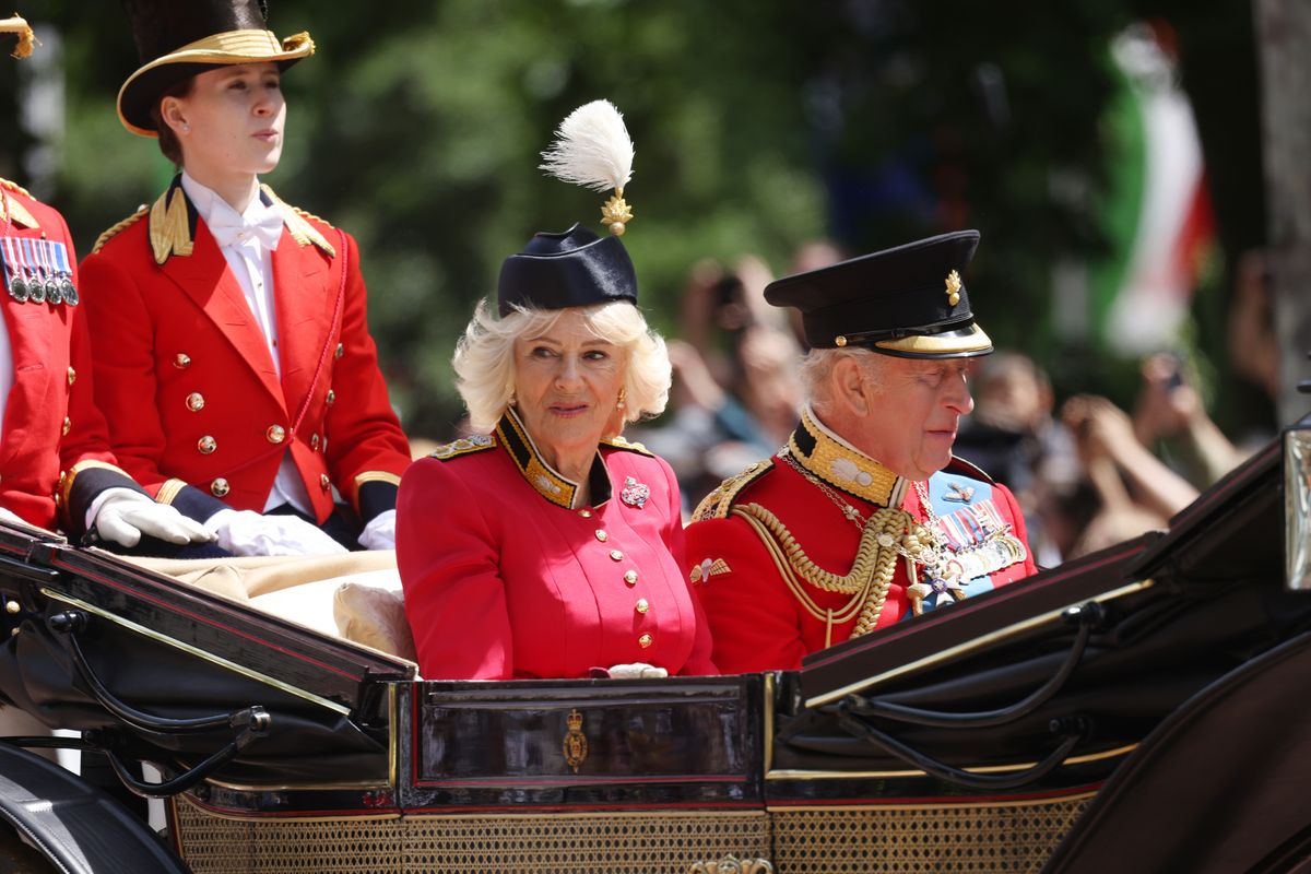 King Charles III and Queen Camilla arrive for Trooping the Colour 2026 in coordinated red ensembles.